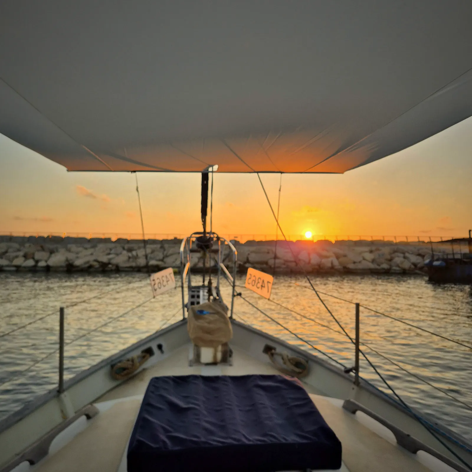 Sunset over the water seen from the foredeck, under the shade of a SunSkipper canopy