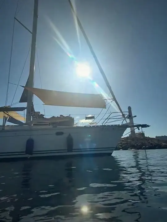The midday sun above a sailing yacht with SunSkipper rigged at the bow